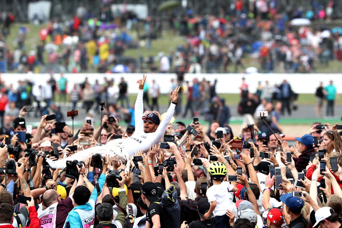 Mercedes driver Lewis Hamilton celebrates winning the British Grand Prix