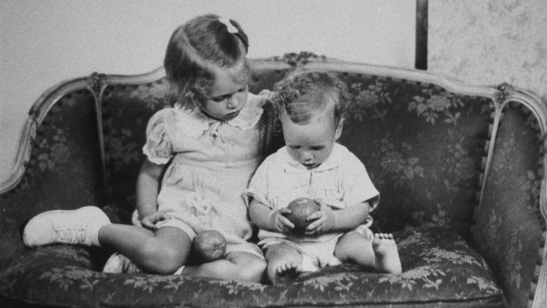 McCain sits on a sofa with his sister, Sandy, in a reproduction of a family photo taken around 1938. McCain was born in 1936 to Roberta McCain and John McCain Jr., a Navy admiral. 