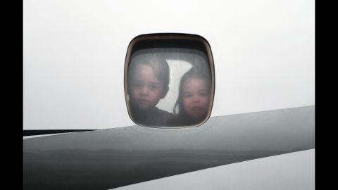 Prince George and Princess Charlotte peer through the window of the plane as they arrive on July 17, in Warsaw, Poland.