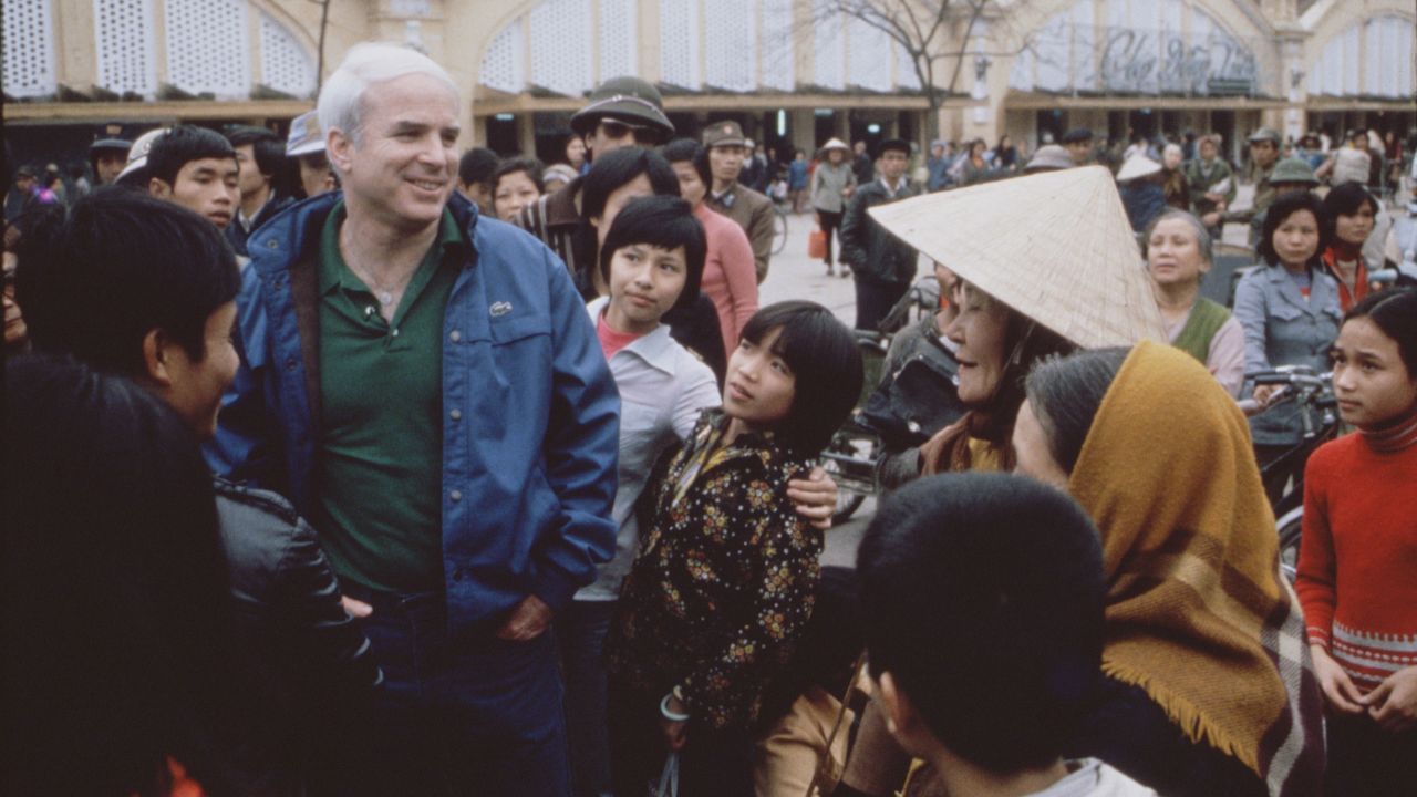 McCain talks with people in Hanoi, Vietnam, during the filming of the CBS special, "Honor, Duty and a War Called Vietnam" in 1985.