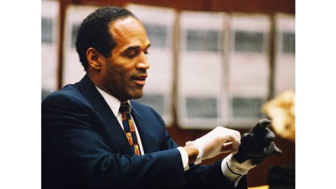 O.J. Simpson tries on a leather glove allegedly used in the killings of Nicole Brown Simpson and Ronald Goldman during testimony in Simpson's murder trial on June 15, 1995, in Los Angeles.