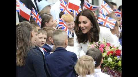 Children welcome Kate in front of the presidential palace in Warsaw upon the royal family's arrival in Poland.