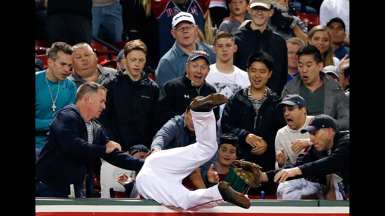 Boston Red Sox's Tzu-Wei Lin flips over into the stands after catching the pop foul by New York Yankees' Jacoby Ellsbury during the ninth inning in Boston on Friday, July 14.