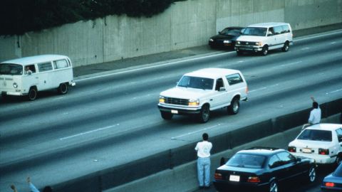 In footage seen on TV screens around the world, police chase a white Ford Bronco with a fugitive Simpson inside on the Los Angeles freeways on June 17, 1994. The Bronco eventually returned to Simpson's home in the Brentwood section of Los Angeles, and he surrendered to police on murder charges in the deaths of his ex-wife and Ronald Goldman.