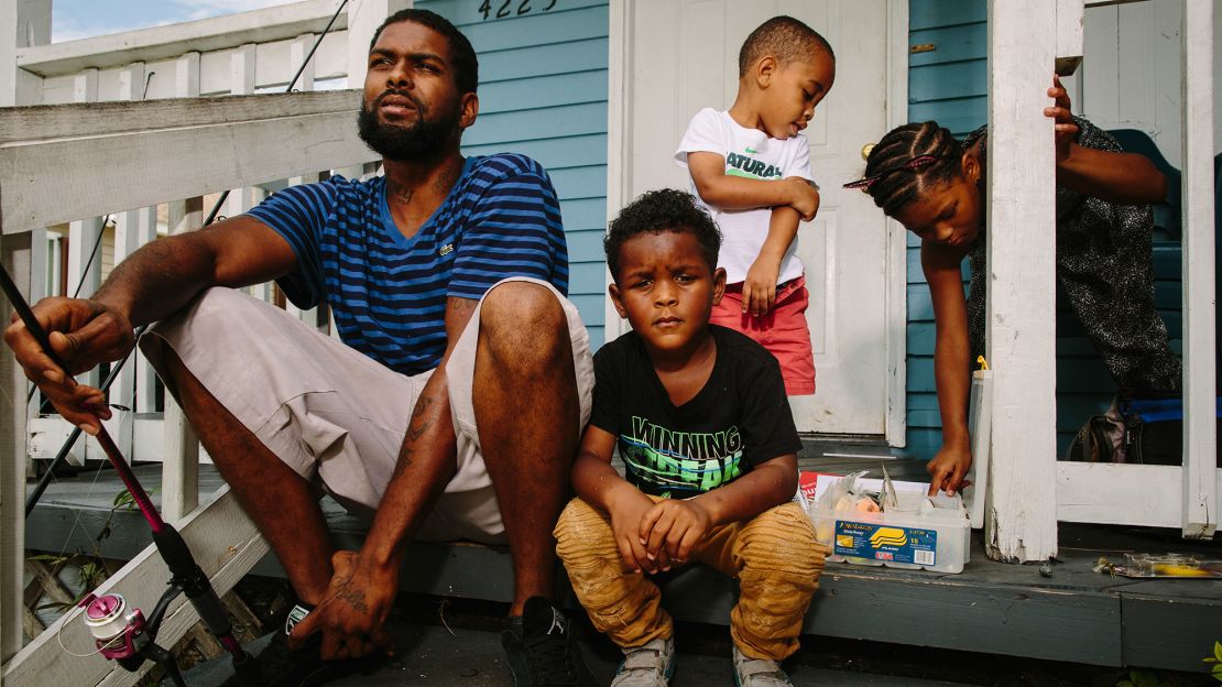 Corey Frazier sits on his porch with his children (from left) Chase, Corey Jr. and Courtney. They helped him realize "the streets ain't for you no more, bruh." He doesn't cut corners talking to them today. "I let them know how life really is."