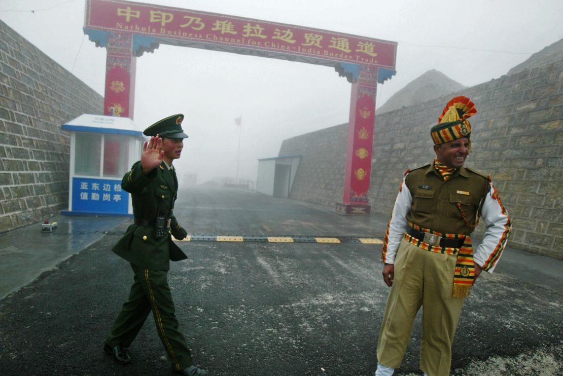 A Chinese soldier (L) and an Indian soldier stand guard at the Chinese side of the ancient Nathu La border crossing between India and China, 2008.  