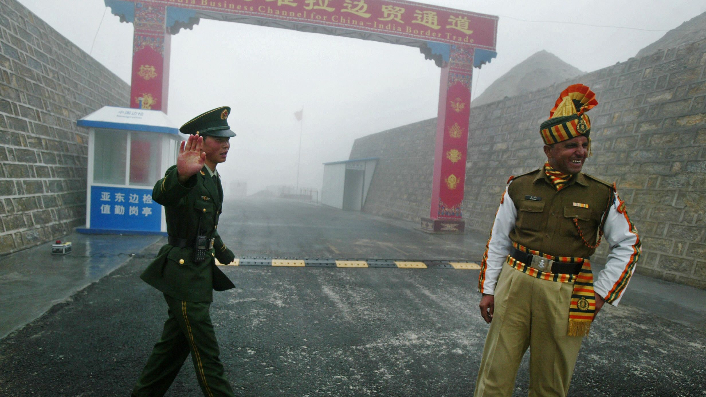 A Chinese soldier (L) and an Indian soldier stand guard at the Chinese side of the ancient Nathu La border crossing between India and China. 