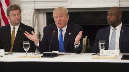 US President Donald Trump speaks alongside US Senator Dean Heller (L), Republican of Nevada, and US Senator Tim Scott (R), Republican of South Carolina, during a meeting with Republican Senators to discuss the health care bill in the State Dining Room of the White House in Washington, DC, July 19, 2017. / AFP PHOTO / SAUL LOEB        (Photo credit should read SAUL LOEB/AFP/Getty Images)