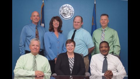 This file photo shows six current board members and retired commissioner Maurice Silva, lower left