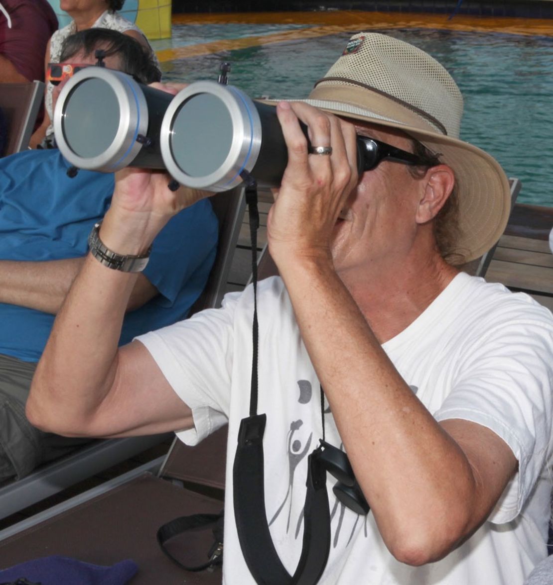 Bill Kramer observing a total solar eclipse through solar filtered binoculars while in Indonesia in 2016.