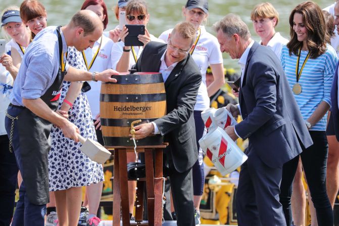 Prince William hammers a tap into a beer barrel as Kate, far right, watches on July 20 in Heidelberg, Germany.