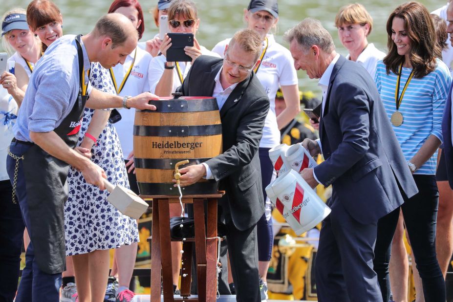 Prince William hammers a tap into a beer barrel as Kate, far right, watches on July 20 in Heidelberg, Germany.