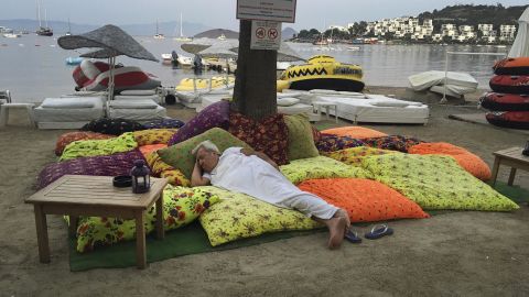 A man in Bitez, a resort town west of Bodrum in Turkey sleeps on the beachfront following the earthquake in the early hours of Friday morning. 