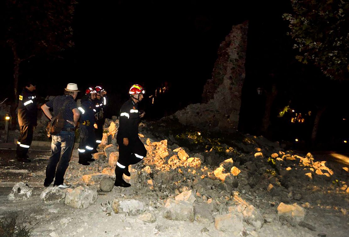 Firefighters assess damaged buildings in the early hours of Friday morning in Kos.
