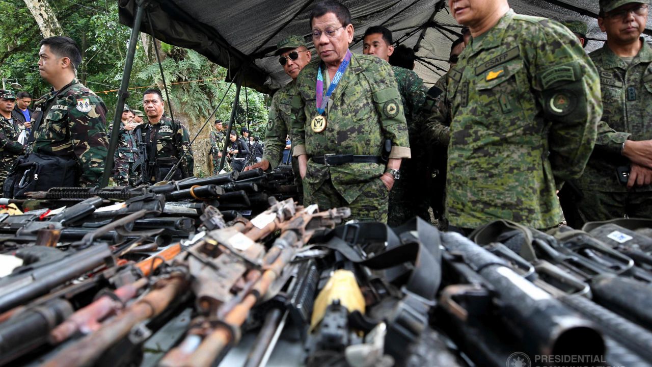 Philippines President Rodrigo Duterte examines captured militant weaponry at Camp Ranao, Marawi, while visiting troops fighting ISIS-aligned militants holed up in the city.