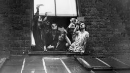 A group gathered in a window to view the total solar eclipse over London through smoked glass. 29th June 1927