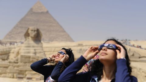 People use protective glasses to catch a glimpse of a solar eclipse in front of Pyramids of Giza and the Sphinx on March 20, 2015 in Giza, Egypt. 