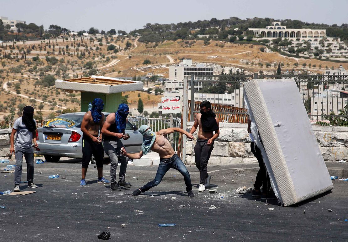 A Palestinian youth hurls rocks towards Israeli security forces outside Jerusalem's Old City on Friday, 21 July.