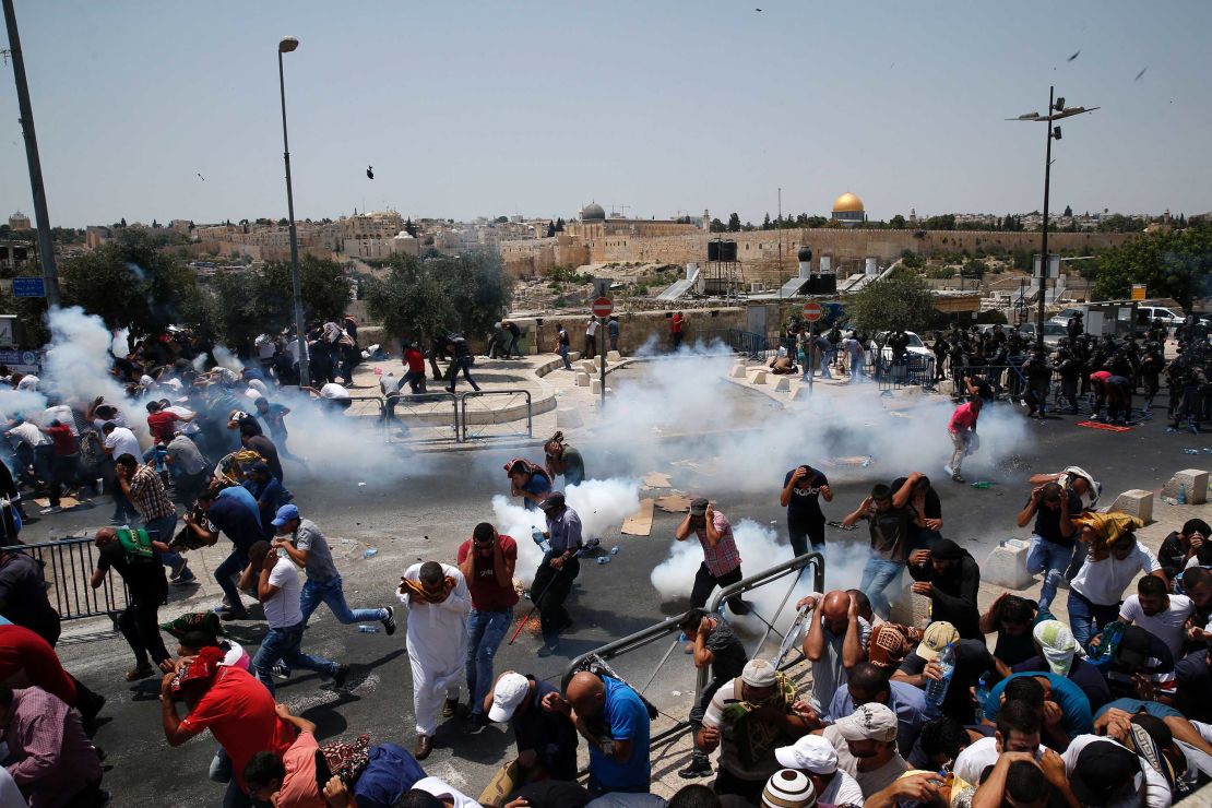 Palestinians run for cover from tear gas fired by Israeli forces following prayers outside Jerusalem's Old City on Friday.
