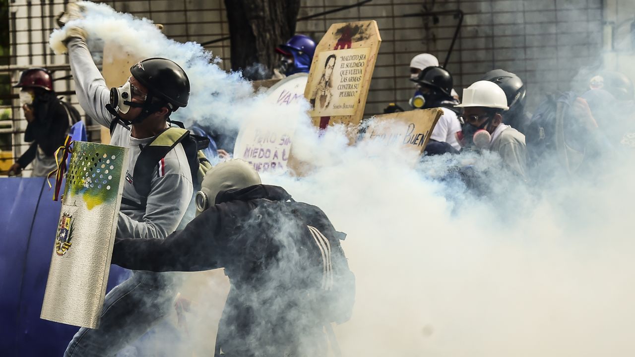 Demonstrators clash with riot police during an anti-government protest in Caracas on July 20, 2017. 
