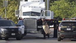 San Antonio police officers investigate the scene where eight people were found dead in a tractor-trailer loaded with at least 30 others outside a Walmart store in stifling summer heat in what police are calling a horrific human trafficking case, Sunday, July 23, 2017, in San Antonio. 