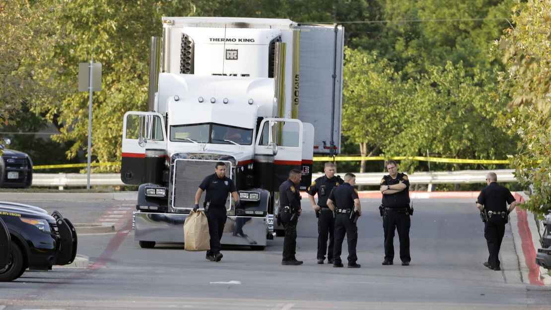 San Antonio officers investigate the scene where people were found dead in a tractor-trailer outside a Walmart.