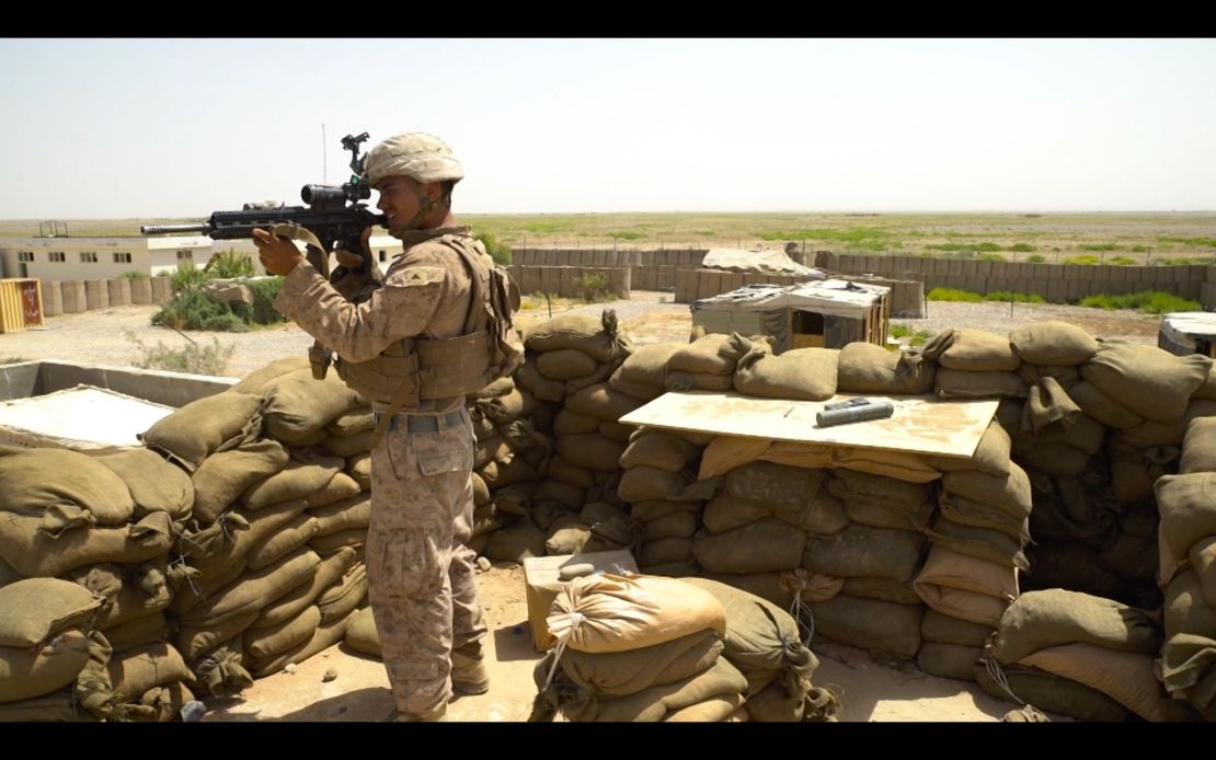 A US Marine in Helmand Province, Afghanistan, looks out through the scope of his assault rifle.