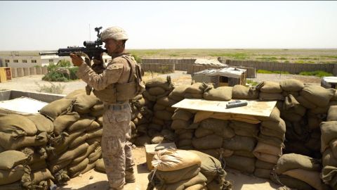 A US Marine in Helmand Province, Afghanistan, looks out through the scope of his assault rifle.