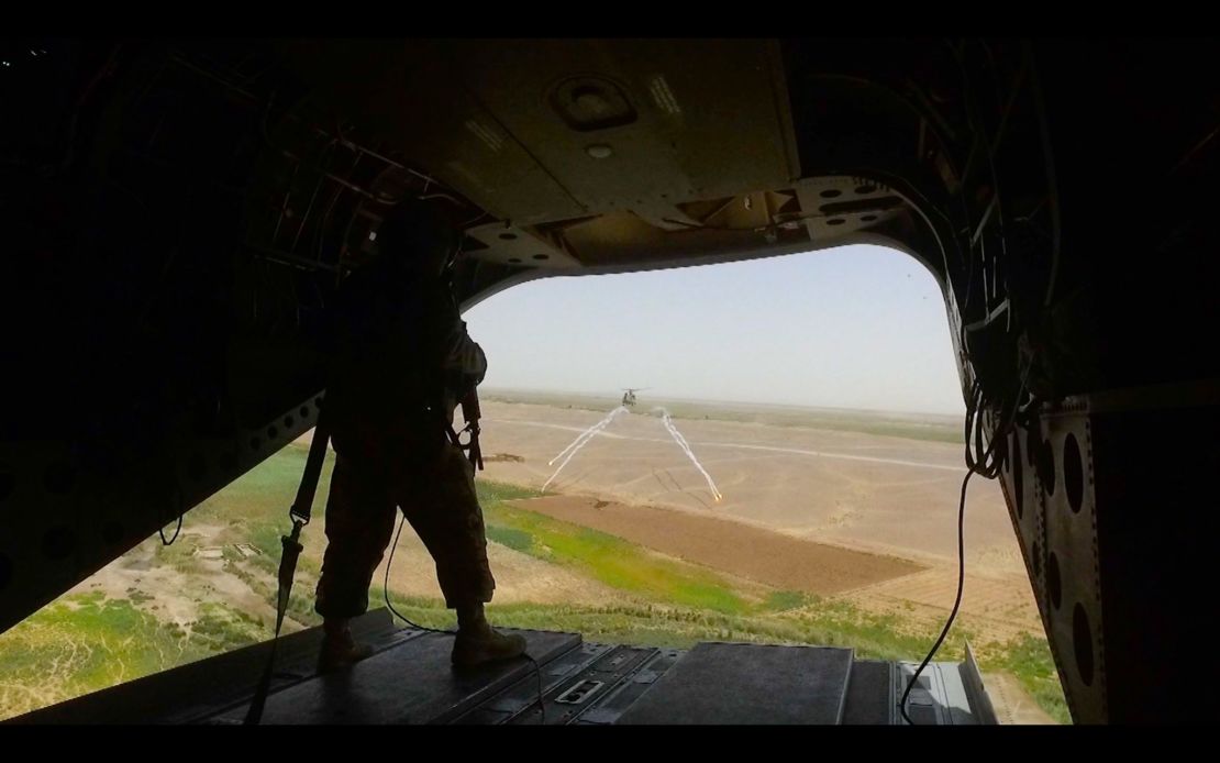 A US Marine stands at the back of a Chinook helicopter en route to Shorsharak.