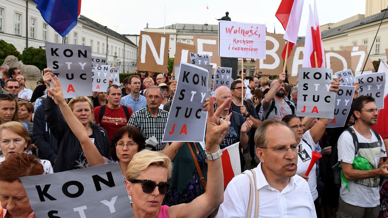 Protesters hold posters reading "constitution" and "I love and understand Freedom" during a protest in front of the presidential palace in Warsaw, as they urge Polish President to reject a bill changing the judiciary system on July 23, 2017. Protesters take to the streets across Poland after lawmakers adopted a controversial reform of the Supreme Court despite the threat of unprecedented EU sanctions. The rallies sprung up after the lower house of parliament, which is controlled by the ruling conservative Law and Justice (PiS) party, voted 235 to 192 -- with 23 abstentions -- in favor of giving the government power to select candidates for the court.