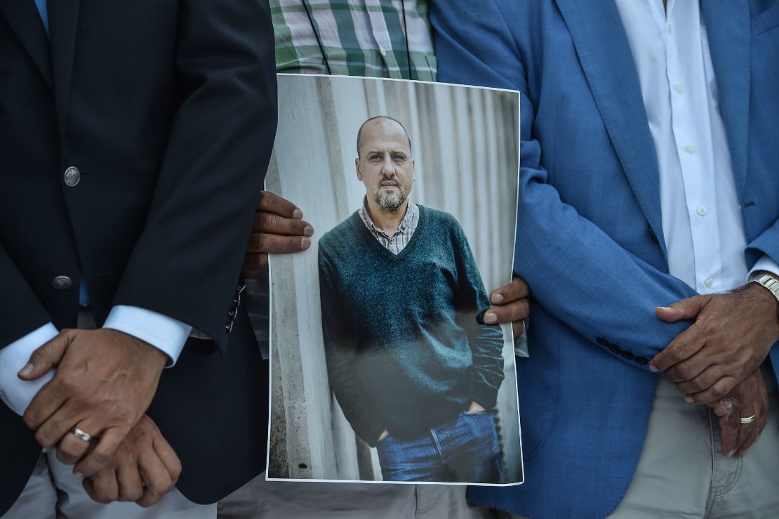 A man holds a portrait of jailed investigative journalist Ahmet Sik outside Istanbul's courthouse