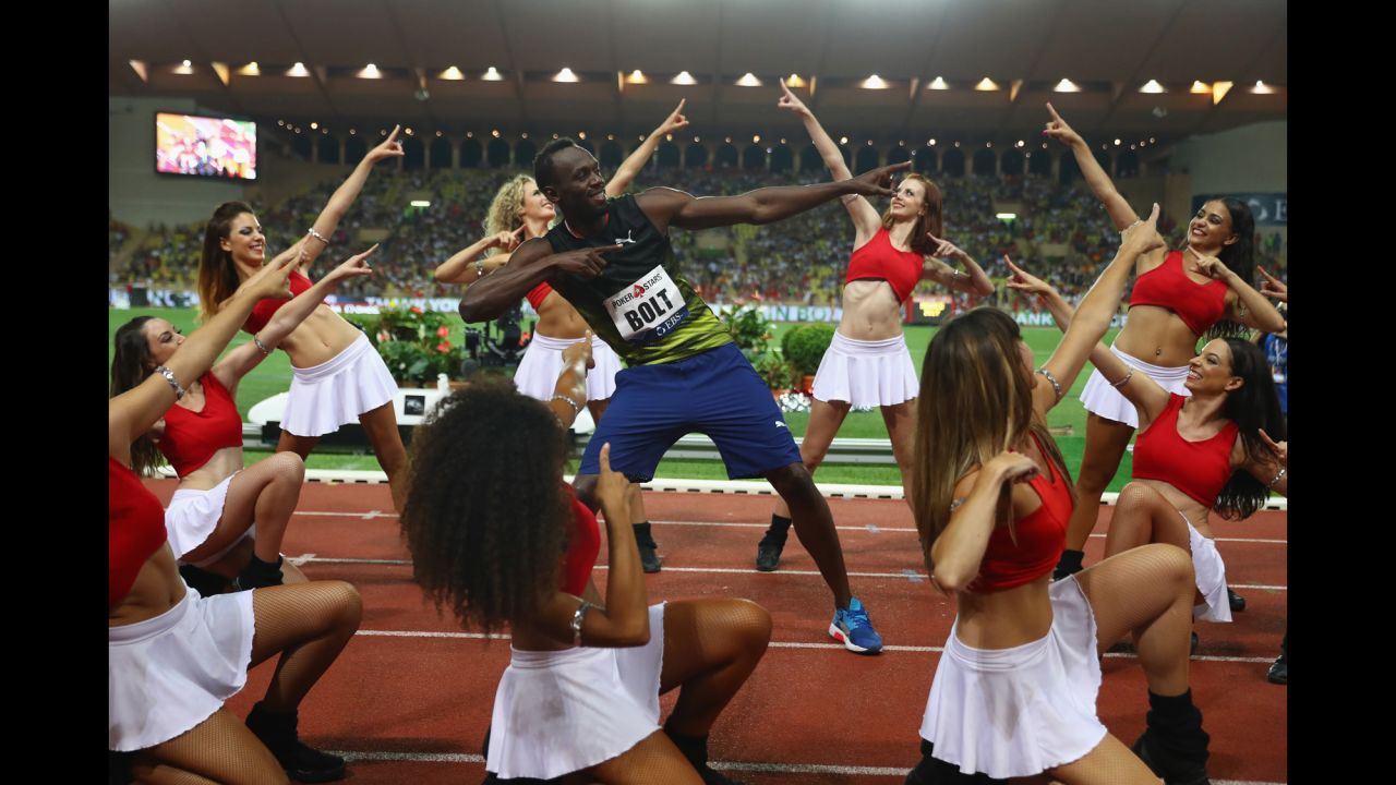 Usain Bolt, the world's fastest man, strikes his signature pose with cheerleaders after winning the 100-meter race at the Diamond League meet in Monaco on Friday, July 21.