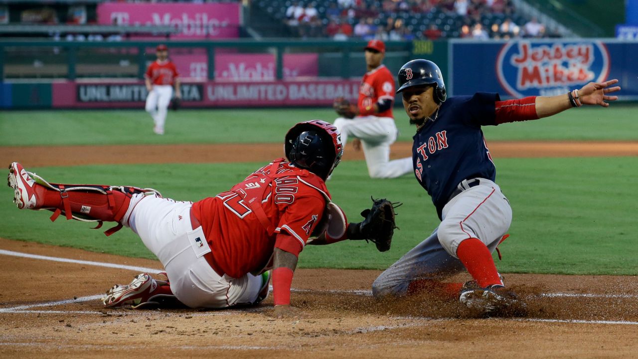 Boston's Mookie Betts, right, slides past Angels catcher Martin Maldonado during a Major League Baseball game in Anaheim, California, on Friday, July 21. It was the start of a five-run first inning for the Red Sox, who won 6-2.