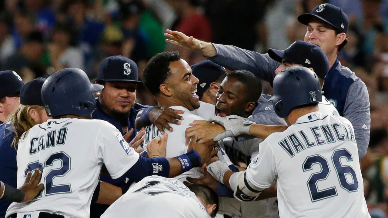 Nelson Cruz is mobbed by his Seattle teammates after his base hit beat the New York Yankees on Saturday, July 22.