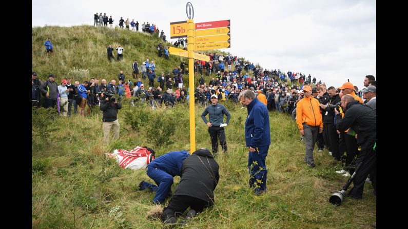 Officials remove a sign at the Royal Birkdale Golf Club so that Rory McIlroy, hands on hips, could play a shot at the Open Championship on Friday, July 21. McIlroy's ball was embedded in the ground, so he was unable to take a free drop to avoid the sign. <a href="index.php?page=&url=http%3A%2F%2Fwww.cnn.com%2F2017%2F07%2F17%2Fsport%2Fgallery%2Fwhat-a-shot-sports-0717%2Findex.html" target="_blank">See 27 amazing sports photos from last week</a>