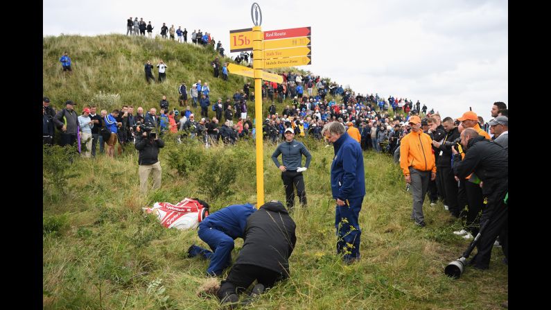 Officials remove a sign at the Royal Birkdale Golf Club so that Rory McIlroy, hands on hips, could play a shot at the Open Championship on Friday, July 21. McIlroy's ball was embedded in the ground, so he was unable to take a free drop to avoid the sign. <a  target="_blank">See 27 amazing sports photos from last week</a>