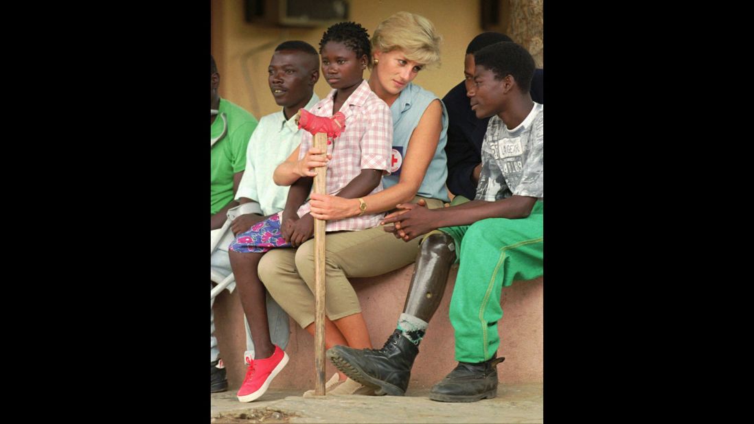 Diana talks to amputees in Angola, where she traveled in January 1997 to bring attention to the anti-land mine campaign of the International Red Cross. Sitting on her lap is Sandra Thijica, a 13-year-old who lost her left leg to a land mine.