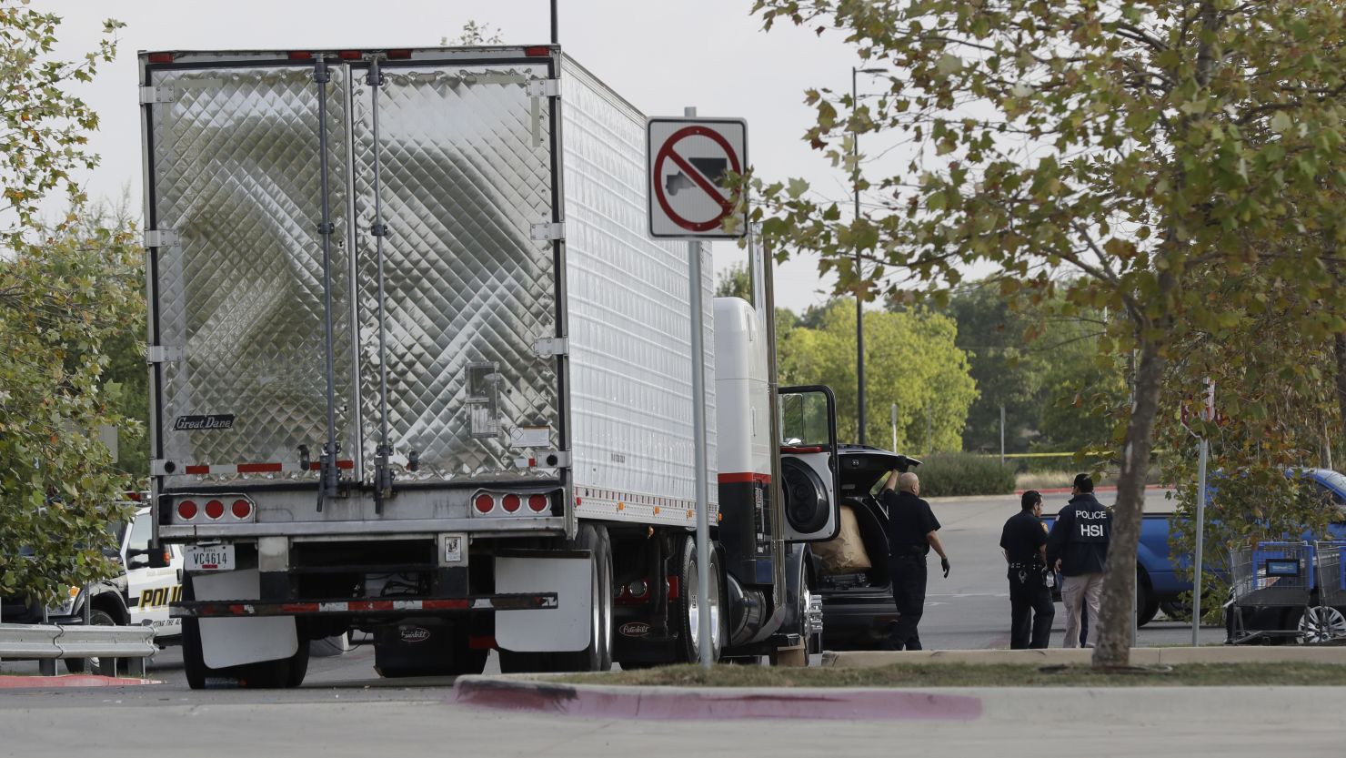 San Antonio police officers investigate the tractor-trailer that carried undocumented immigrants.