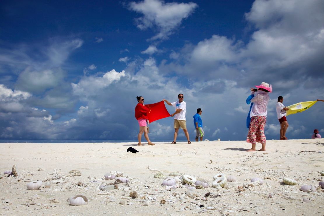 Chinese tourists pose with the country's flag as they visit the Parcael Islands.