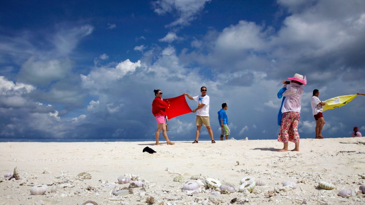 Chinese tourists pose with the country's flag as they visit the Parcael Islands.