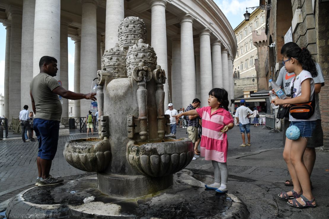 People fill bottles from a fountain near St. Peter's Square, just outside Vatican City, on Tuesday.