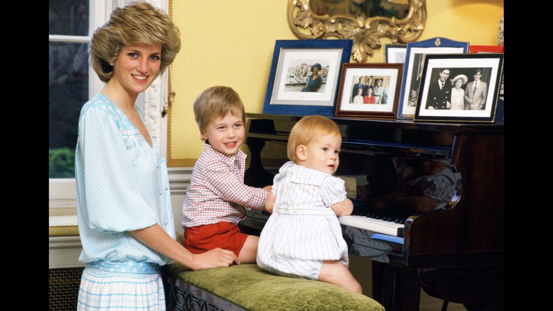 Diana watches her boys play at the piano in Kensington Palace in October 1985.