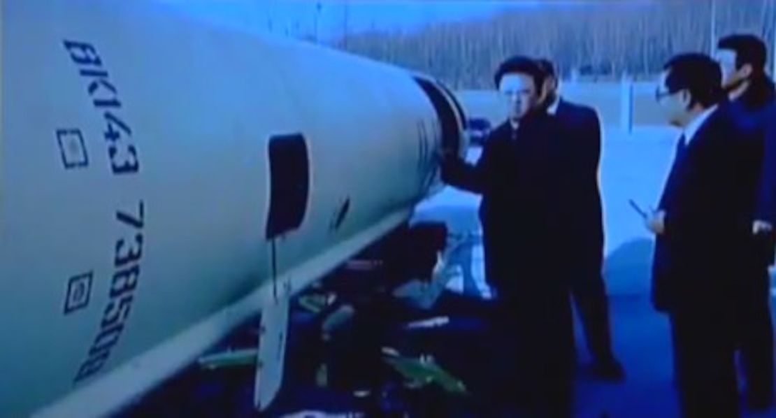 Former North Korean leader Kim Jong Il stands near what appears to be a Scud-B missile.