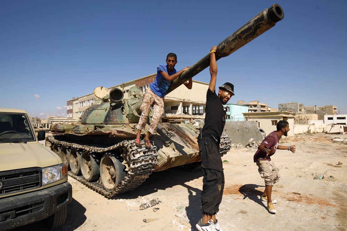 Members of Haftar's army pose with a tank in the city of Benghazi in July. 