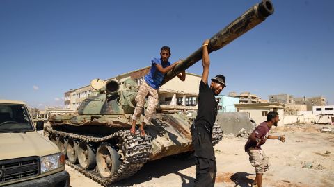 Members of Haftar's army pose with a tank in the city of Benghazi in July. 