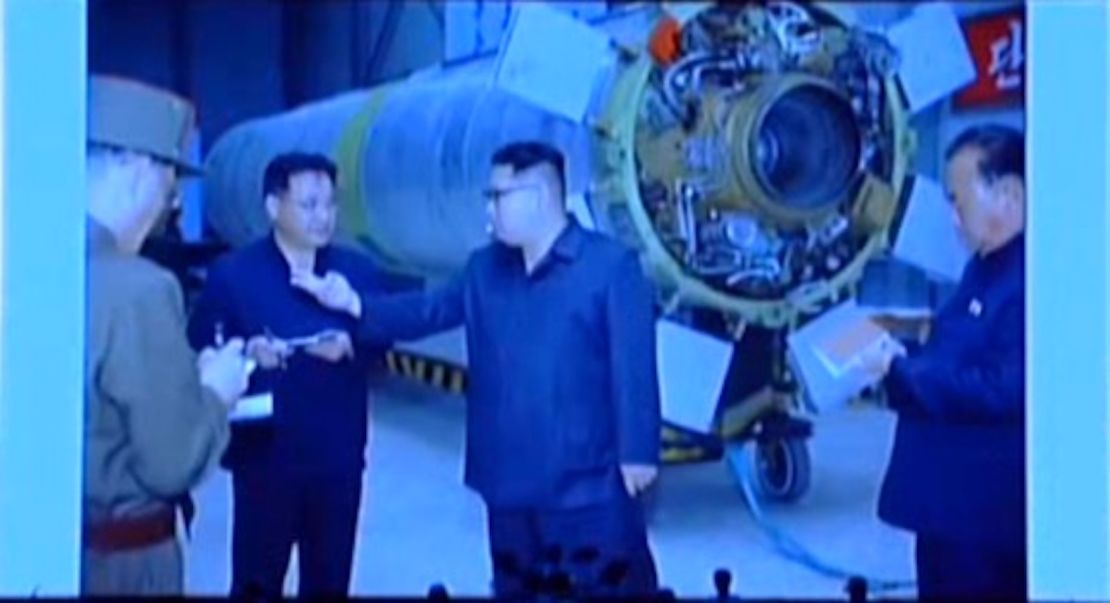 North Korean leader Kim Jong Un standing in front of the Hwasong-10, with the engine visible.
