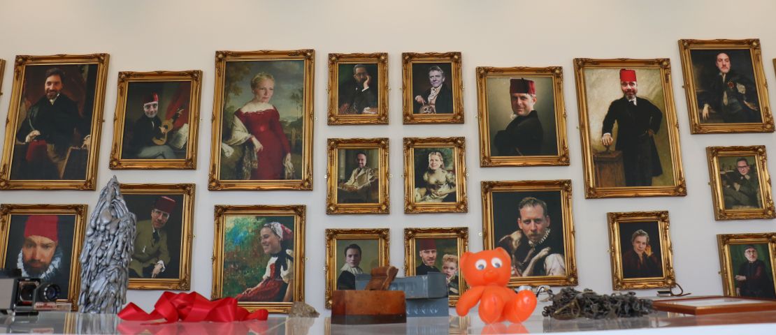 A wall of portraits show to member-contributors to the Learned Society of Extra Ordinary Objects. 