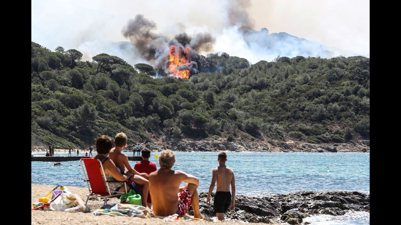 People watch a wildfire burn near a beach in La Croix-Valmer, France, on Tuesday, July 25.