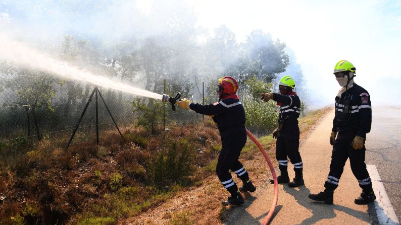 Firefighters try to extinguish a fire burning in Artigues on July 25.