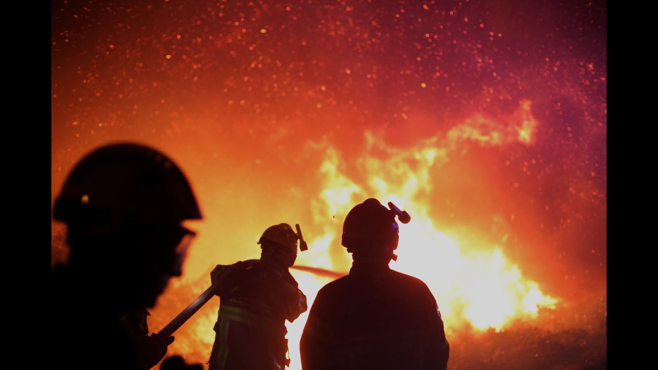 Firefighters douse a fire near Biguglia on July 25.